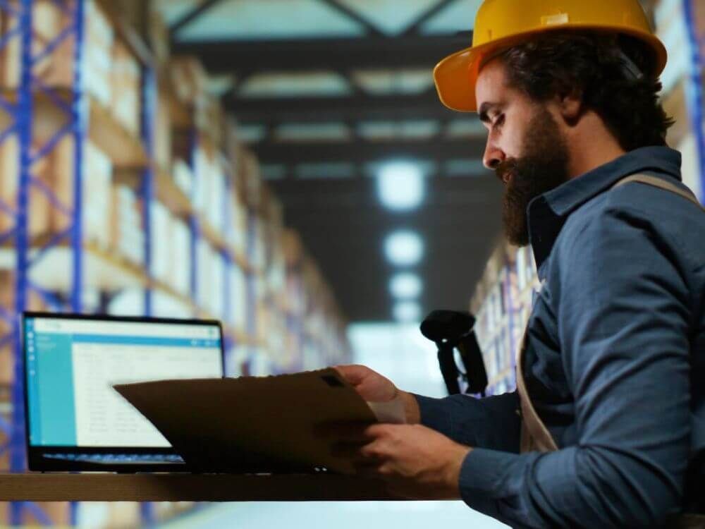 Mann bei der Arbeit im Lager vor Computer