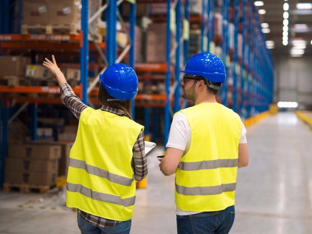 Mitarbeiter mit Warnweste bei der Arbeit im Lager